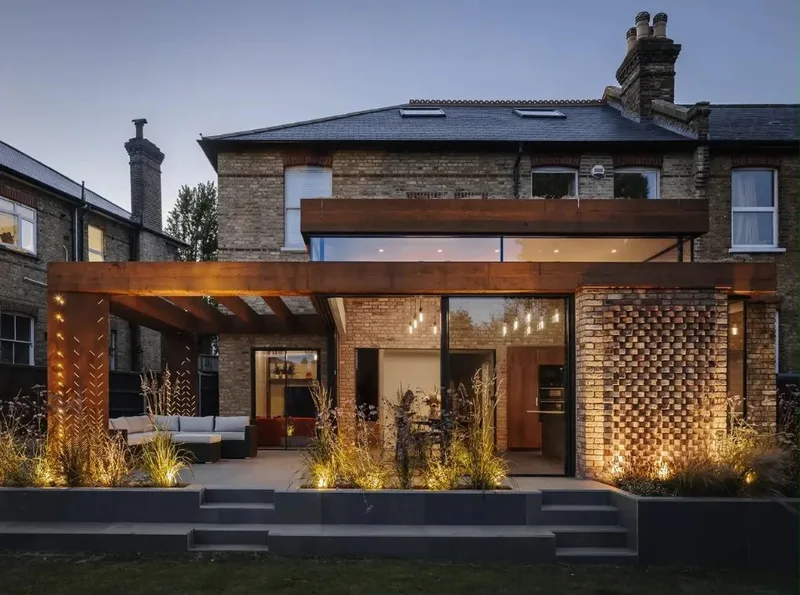 Modern home extension with pergola and large glass panels