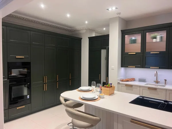 Large bespoke green kitchen with island and stools